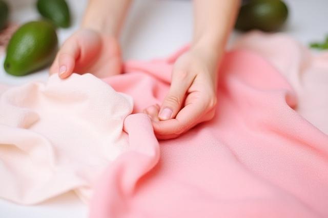 Fabric naturally dyed with a soft pink hue from avocado pits, laid out to dry.